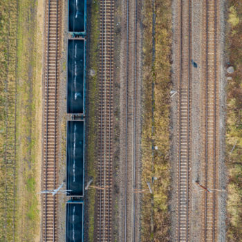 Zdjęcie: widok z powietrza na stację kolejową Toszek Północ, widać niebieski pociąg towarowy