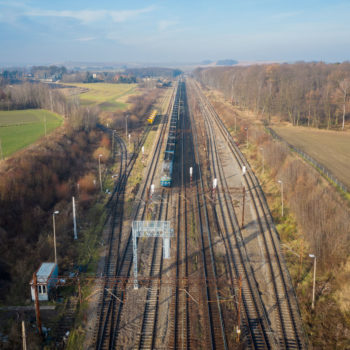 Zdjęcie: widok z powietrza na stację kolejową Toszek Północ, widać niebieski pociąg towarowy