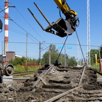 Zdjęcie: dźwig wyrywa szyny na ulicy Piastowskiej w Chełmku. Zbliżenie.