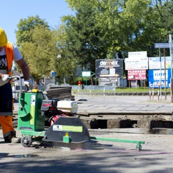 Zdjęcie: robotnik wycina asfalt na przejeździe kolejowo-drogowym w Chełmku.