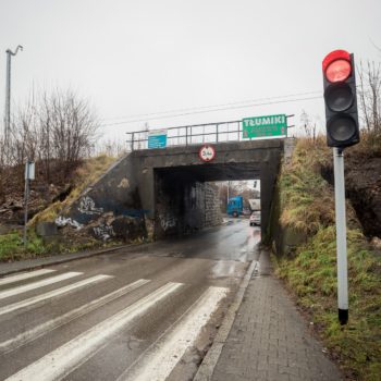 Zdjęcie: widok na jeszcze nie odnowioną część wiaduktu kolejowo-drogowego nad ulicą Kadłubka w Chrzanowie. Na pierwszym planie sygnalizacja świetlna.