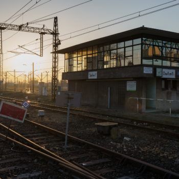 Zdjęcie: zachód słońca nad budynkiem kolejowym w Oświęcimiu.