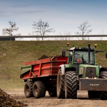 Zdjęcie: widok na traktor przewożący ziemie.