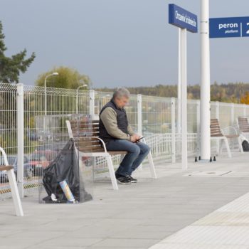 Zdjęcie: podróżny siedzi na ławce na przystanku Chrzanów Śródmieście.