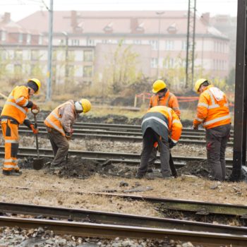 Zdjęcie: robotnicy pracują przy torach.