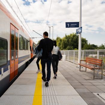 Zdjęcie: podróżujący wsiadają do pociągów.