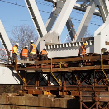 Zdjęcie: robotnicy pracują przy konstrukcji nowego mostu.