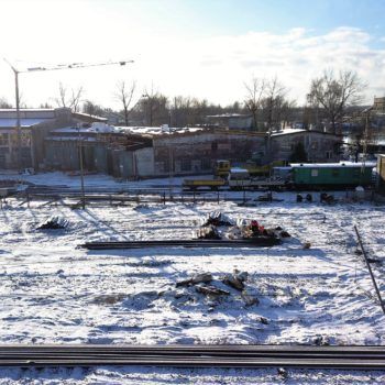Zdjęcie z lotu ptaka przedstawia prace budowlane odbywajace się w Katowicach Szopienicach Północnych. Wszędzie leży śnieg.