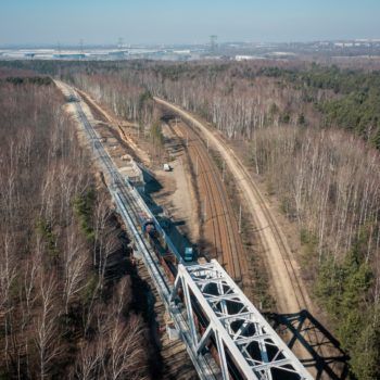 Zdjęcie: pociąg towarowy przejeżdża przez wiadukt.